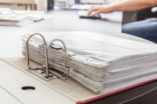 Aglutinante abierto con papeles en envolturas de plástico en el escritorio por la m — Foto de Stock