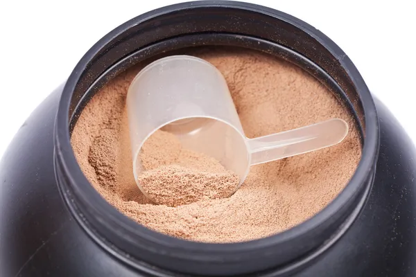 Scoop of chocolate whey isolate protein in a black plastic conta — Stock Photo, Image