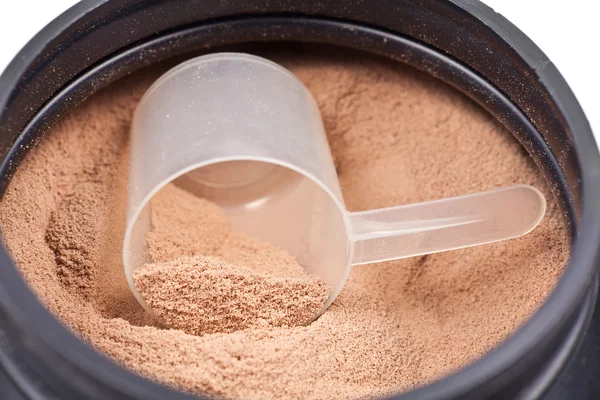 Scoop of chocolate whey isolate protein in a black plastic conta — Stock Photo, Image