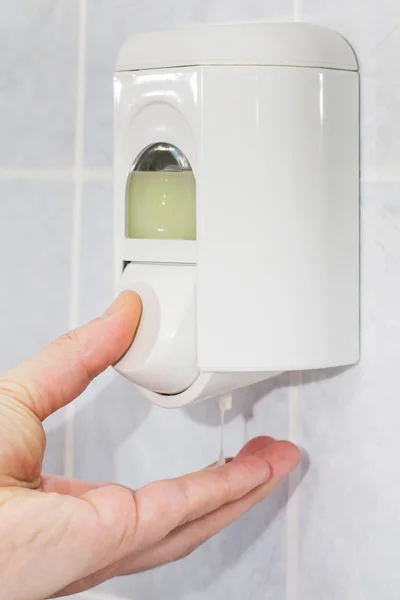 Man's hand holding soap from the soap dispenser — Stock Photo, Image