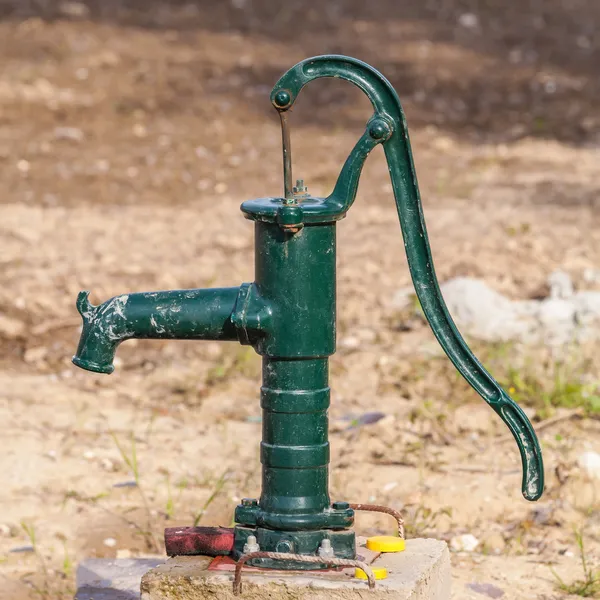 Pompa acqua verde arrugginita manuale in giardino — Foto Stock