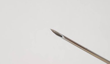 Beyaz arkaplanda bir şırınga iğnesini kapat