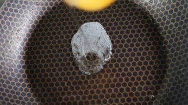 Kırık yumurta tavaya yavaş çekimde düşer.