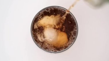 Buzlu çay bardağa buz küpleriyle dökülüyor.