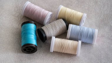 Colored sewing thread reels on fabric