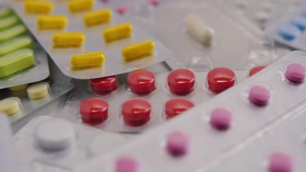 Packungen mit bunten Pillen. Blasen mit Antibiotika, Kapseln, Tabletten und Medikamenten — Stockvideo