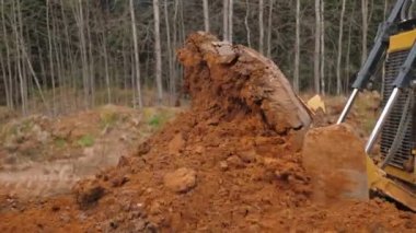 Sürüngen buldozer seviyesinde zemin, ağır dereceli tırmıklar toprağı kaplıyor.