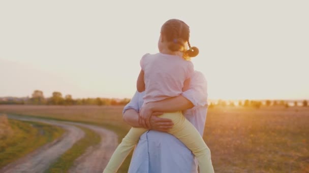 Mamma håller söt baby i armar, vid solnedgången, kramar varandra, slow motion — Stockvideo