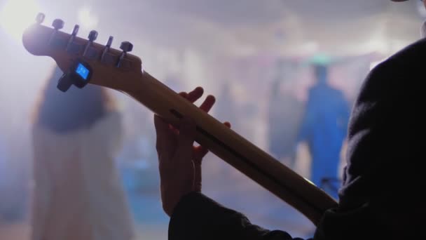 Músico de rock toca guitarra em concerto ou festa, de pé no palco, banda tocando — Vídeo de Stock