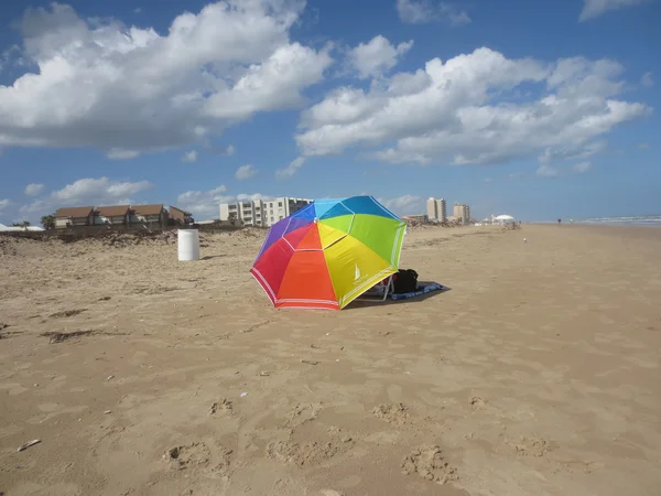 Colored-umbrella-on-the-beach-sand-under-a-fluffy-clouds-bright-blue-sky — Stock Photo, Image