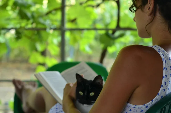 Дівчина, книга і кіт — стокове фото