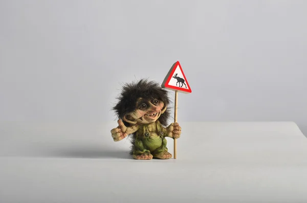 Otostop ve geyik ile bir yol işaret tutan küçük bir Norveçli troll