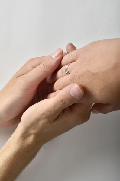 bir adamın eli olan bir evlilik yüzüğü iki kadının eller tarafından düzenlenmektedir