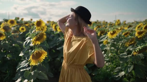 Руда жінка на соняшниковому полі на фотосесії робить фотографії по телефону — стокове відео