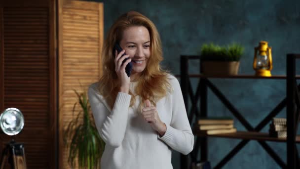 Zrzka žena při stání v podkroví byt mluví na telefonu se svým přítelem — Stock video