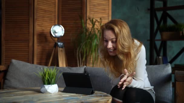 Rothaarige schöne kaukasische Frau im Loft-Stil kommuniziert per Tablet — Stockvideo