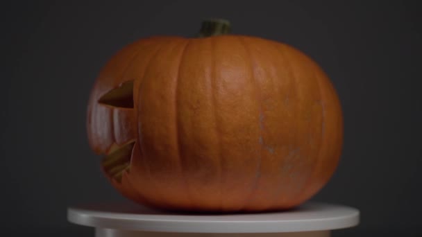 Непрерывное вращение тыквы Хэллоуина на круглой легкой платформе — стоковое видео
