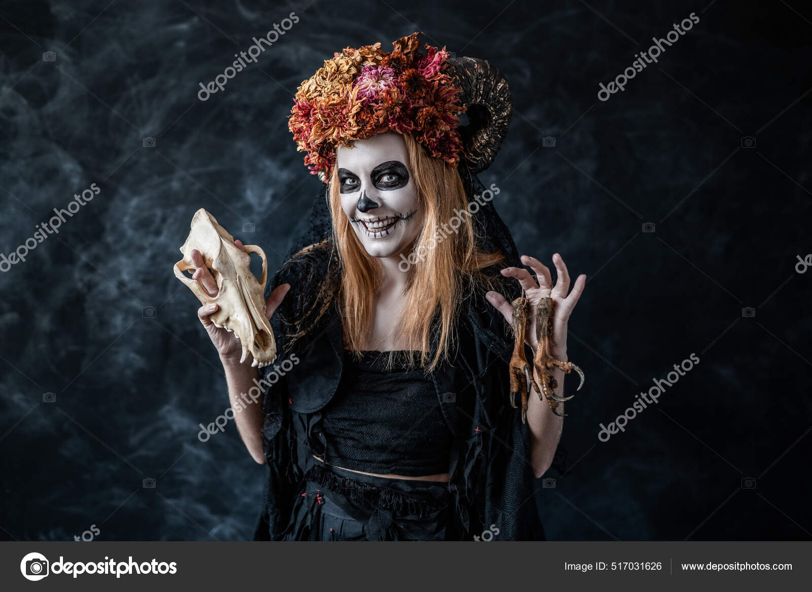 Halloween witch with skull, horns conjures in dark room, smiles
