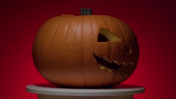 Halloween dýně s dinamik světlo na rotační plošině, červené pozadí — Stock video