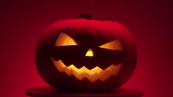 Halloween abóbora com luz dinamik na plataforma, fundo vermelho — Vídeo de Stock
