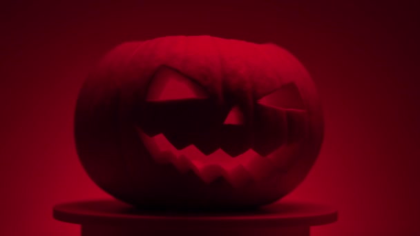 A sötét halloween tök folyamatos forgása kerek világító platformon — Stock videók