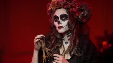 Kainat tarzı makyajlı bir kadın. Karanlık odada, kırmızı ışıklı bir ölü için.