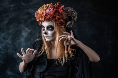 Bacakları olan cadılar bayramı cadısı, karanlık odada boynuzlar, bel planı.