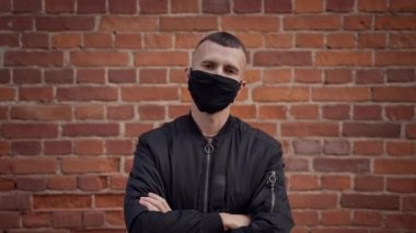 Kısa saçlı bir kabadayı gibi koruma çıkar ve koruyucu maske takar.