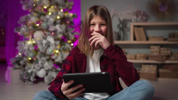 Adolescente chico se sienta en la alfombra en Año Nuevo Eve risas, se divierte en el interior festivo — Vídeo de stock