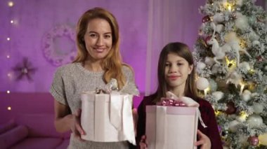 Anne, uzun saçlı ergen yılbaşı arifesinde içinde Noel hediyeleri olan kutular hazırladı.
