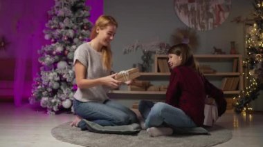 Bekar anne, uzun saçlı ergen oğluyla yılbaşı hediyelerini değiş tokuş ediyor.
