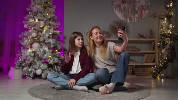 Mujer caucásica, hijo adolescente iniciar el chat de vídeo en la sala de estar con árbol de Navidad — Vídeo de stock