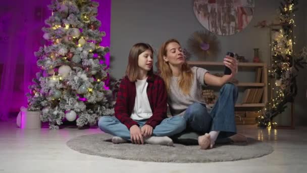 Familj i vardagsrum med xmas träd avsluta videochatt med vänner på telefon — Stockvideo