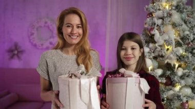 Kızıl saçlı bekar anne ve uzun saçlı genç oğlu hediye kutuları alıp gülüyorlar.