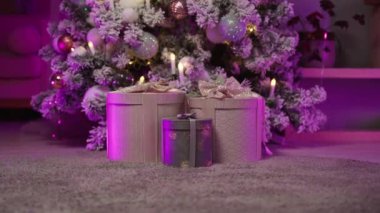 Yeni yıl için hediye kutuları balolarla süslenir, mumlarla süslenir.