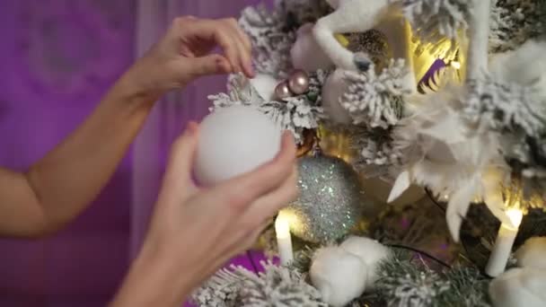 Manos se están preparando para el nuevo año, bola colgante en el árbol de Navidad cubierto de nieve — Vídeo de stock