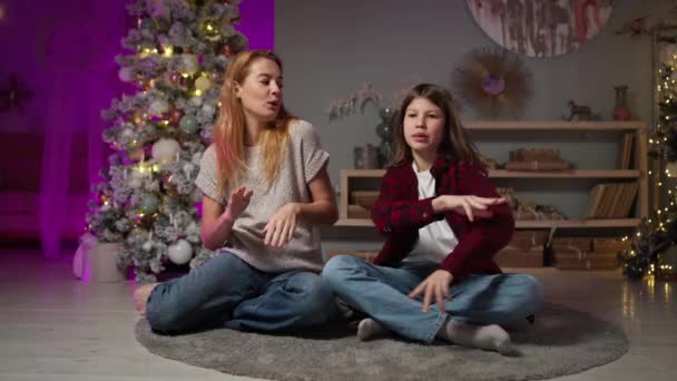 Mãe dançando, brinca com o filho adolescente na véspera de Ano Novo no quarto com árvore de Natal — Vídeo de Stock