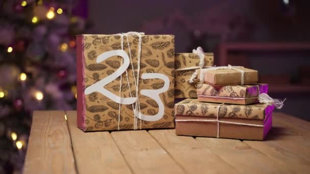 Silvesterkonzept. Geschenkboxen auf dem Tisch gegen geschmückten Weihnachtsbaum — Stockvideo