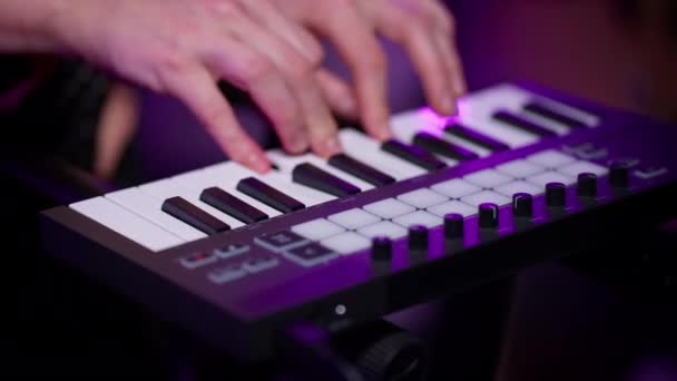 Κοντινό πλάνο των χεριών του κοριτσιού DJ χωρίς μανικιούρ εκτελεί μελωδία για synthesizer — Αρχείο Βίντεο
