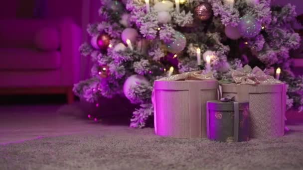 Dozen met geschenken voor Nieuwjaar zijn versierd met ballen, sprankelende kaarsen boom — Stockvideo