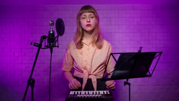 Online εκμάθηση για να παίξει το συνθεσάιζερ. Κορίτσι μουσικός σε στούντιο ηχογράφησης — Αρχείο Βίντεο