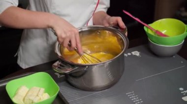 Profesyonel bir aşçı çırpıcıyla noel pastası hamuru yoğurur.