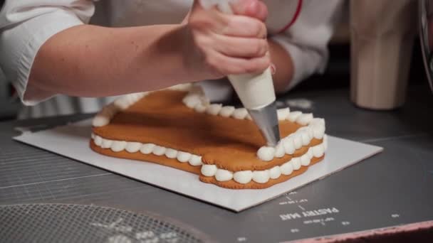 The pastry chef squeezes the cream onto the cake. Close-up — Stockvideo