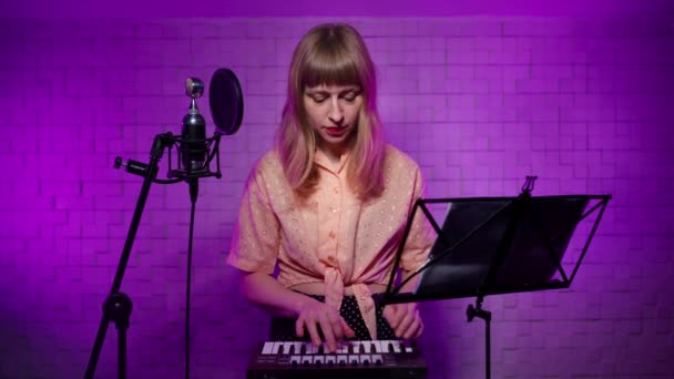 Çevrimiçi olarak sentezleyici çalmayı öğreniyorum. Kayıt stüdyosundaki kız müzisyen. — Stok video