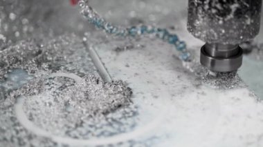 CNC operasyonunun yavaş çekim yakın çekimi. Metal talaşlarıyla kaplı Alimium parçası
