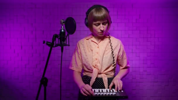 Musician girl demonstrating rock and roll hand gesture in recording studio — стоковое видео