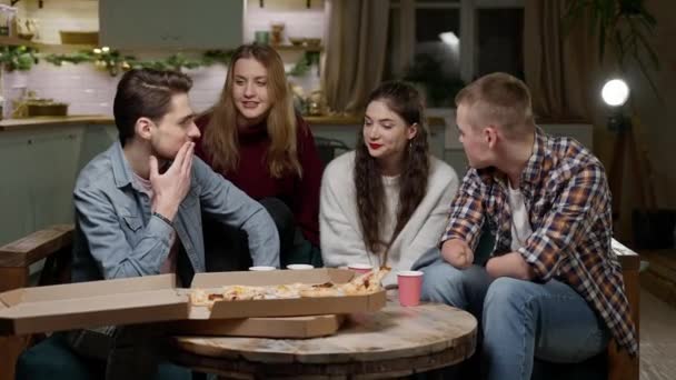 Company of four young guys, girls clink cardboard cups at home pizza party — 图库视频影像