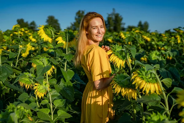 Satisfied girl with red hair turned to camera, smiling, squinting from sun Stock Photo