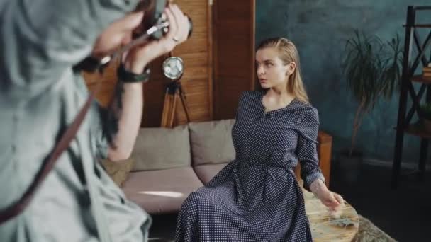 Fotograf fotografuje modelkę w studiu. — Wideo stockowe