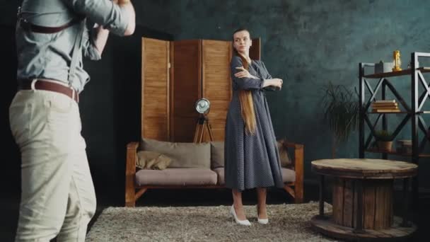 Menina modelo de cabelos compridos em poses vestido para fotógrafo no quarto de loft-estilo — Vídeo de Stock